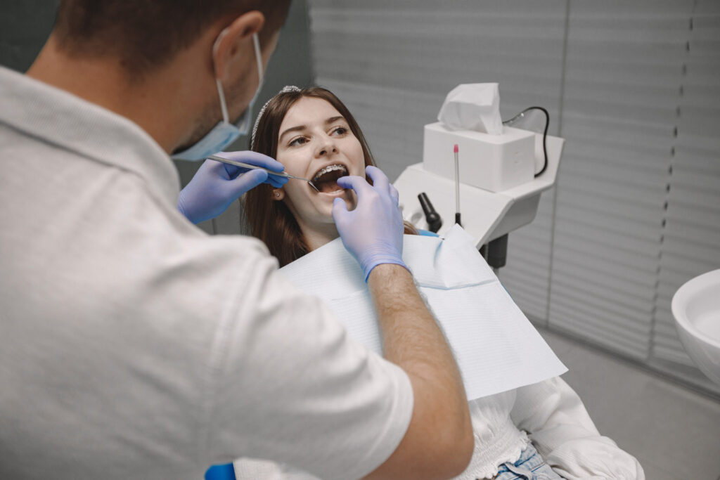 Dentist examining a patient for dentures near Long Beach, California, at Art Family Dental